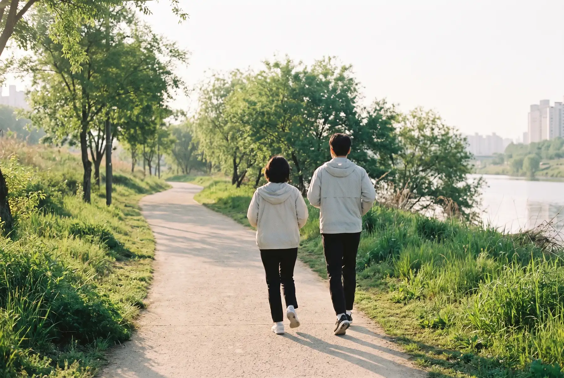 강변 산책로를 나란히 걷는 부부의 뒷모습